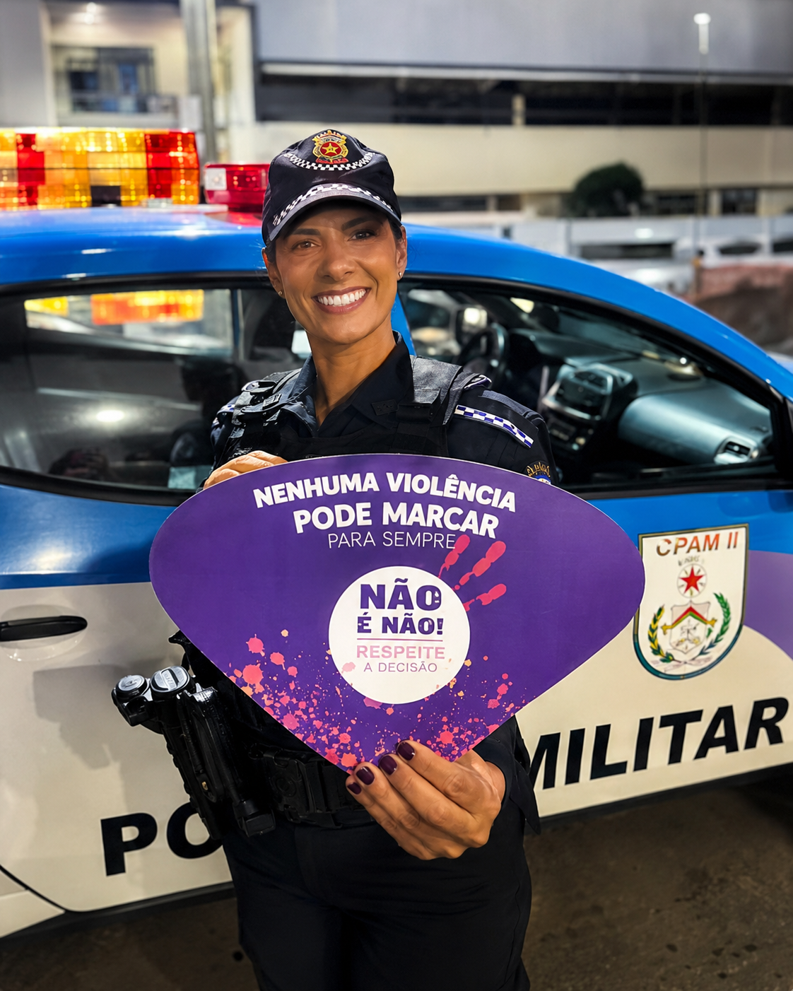 Policial segurando material da campanha Maria da Penha